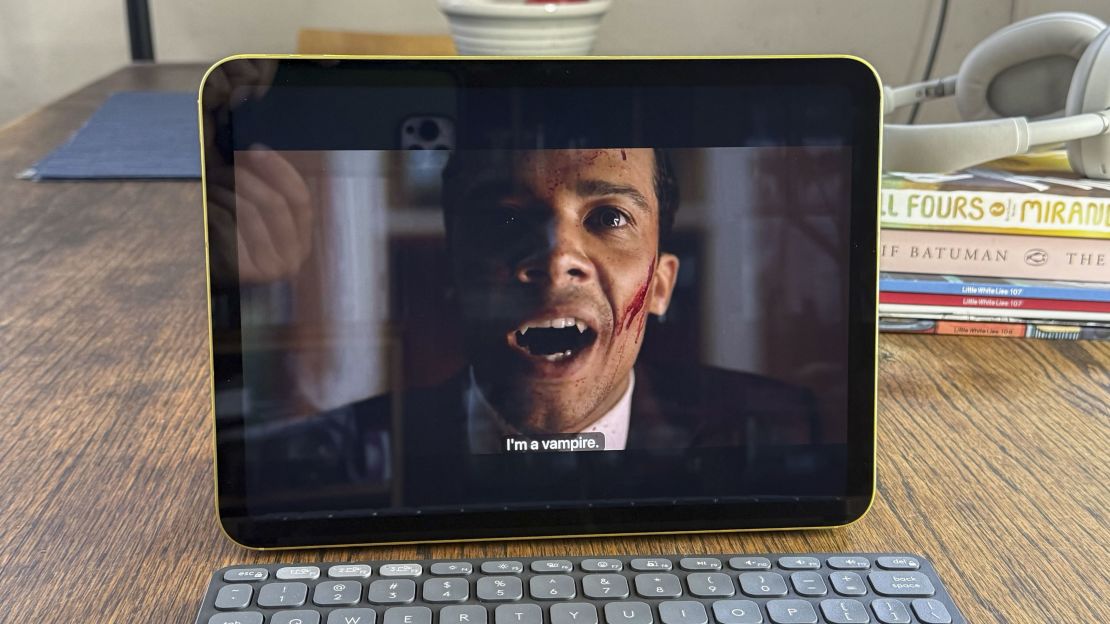 Henry's reflection is visible on the iPad 11, which is showing a video where a man says "I'm a vampire"