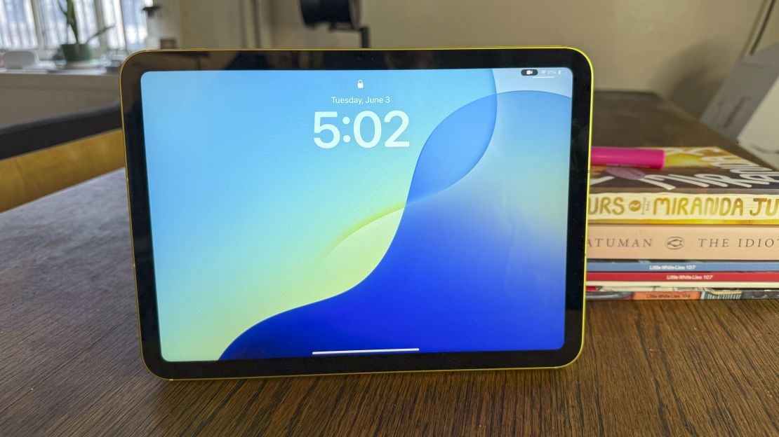 The iPad 11 is open to its lock screen on a table
