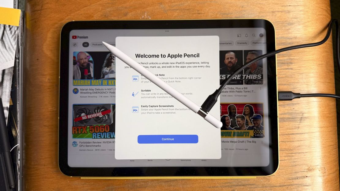 An Apple Pencil is connected to the iPad 11 via a cable