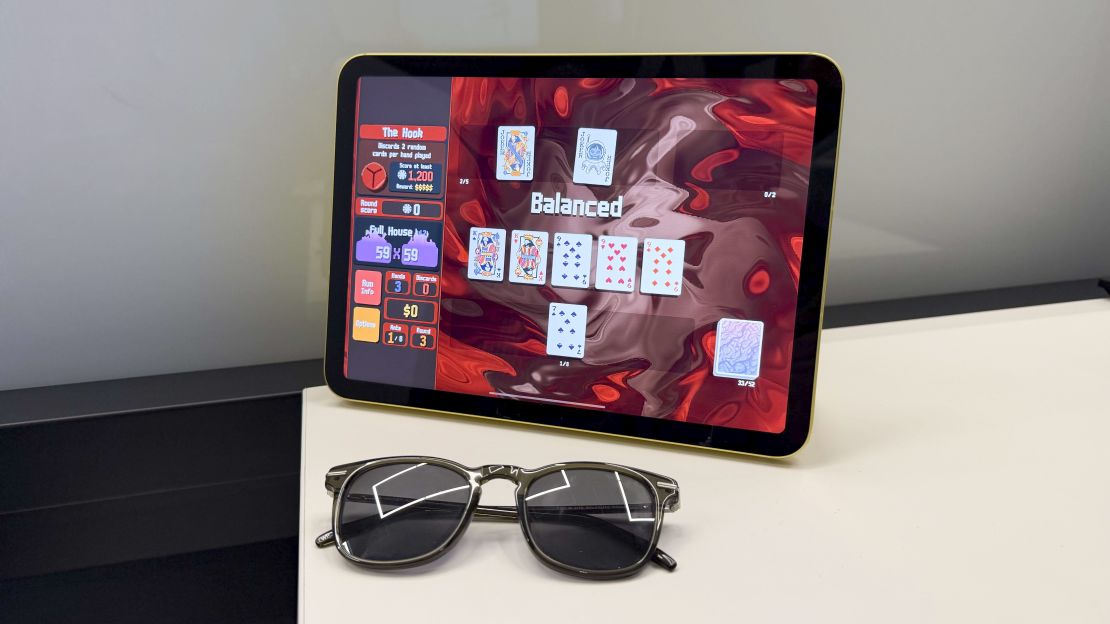 The iPad 11 is playing the card game balatro and sunglasses are in the foreground