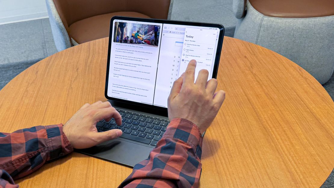 Someone is multitasking on the iPad Pro M4 with its screen split between apps including a text editor and a to-do list.