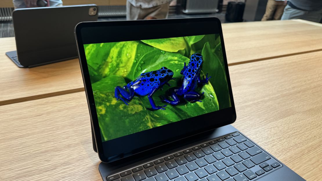 An iPad Pro M4 attached to its magic keyboard shows an image of blue frogs on green leafs