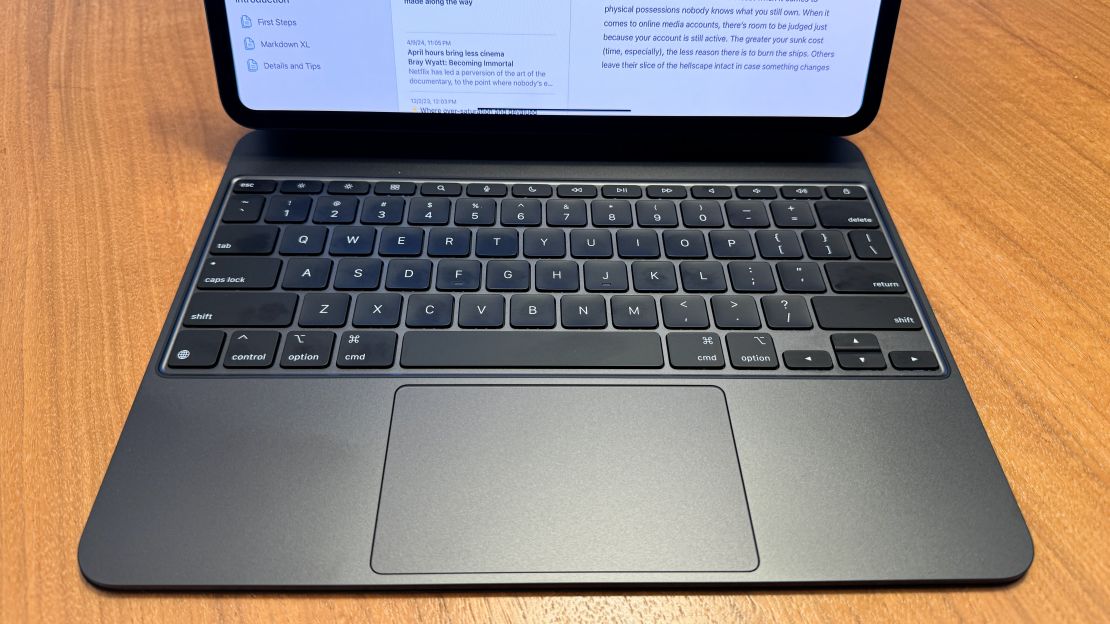 The Apple Magic Keyboard for iPad Pro's metallic deck and keyboard is in focus while the iPad Pro M4 is above it.