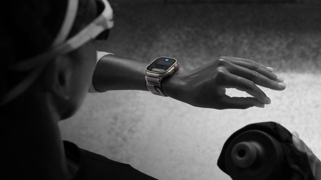 A smartwatch wearer lifts their wrist and taps their fingers together to trigger the watch's accessible feature.