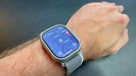 A smartwatch on a person's left wrist shows a map on its screen.