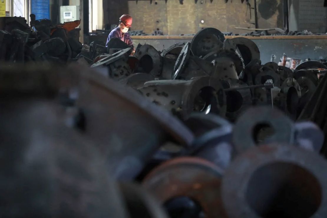 Un trabajador se sienta entre maquinaria en el taller de una fábrica que produce maquinaria de acero para la exportación, en Hangzhou, en la provincia oriental china de Zhejiang, el 21 de febrero de 2025.