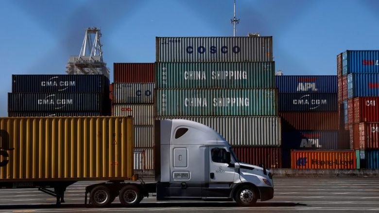 Un camión pasa junto a contenedores apilados en el Puerto de Oakland, California, el 20 de mayo. El Puerto de Oakland registró una disminución del 14,7 % en el volumen total de carga en abril tras la promulgación de los aranceles de la istración Trump.