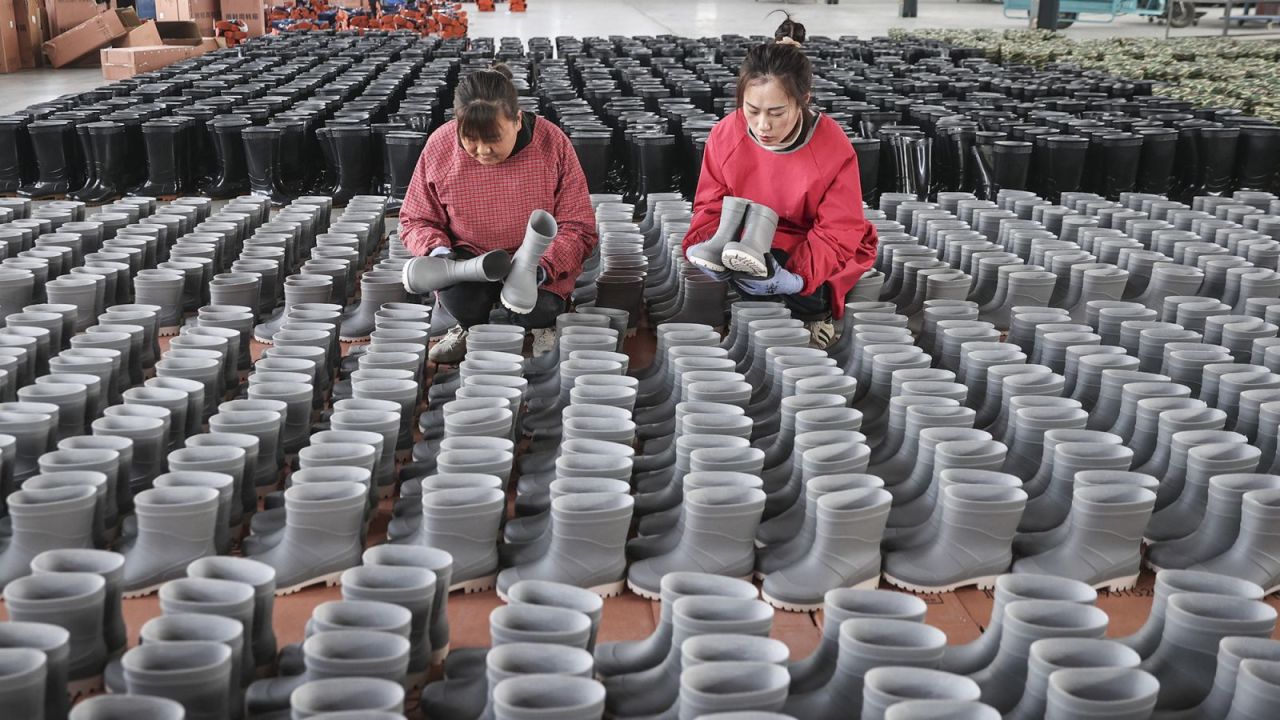 Los empleados revisan las botas de lluvia para exportación en una fábrica de zapatos en Lianyungang, en la provincia de Jiangsu, en el este de China, el 13 de marzo de 2024.