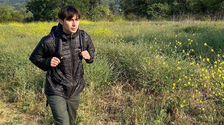 Man walking on hiking path wearing black patagonia nano puff hoodie