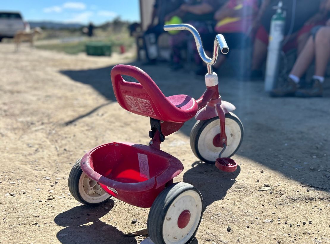 A red tricycle sits in the sun near Arlene Henry's home.