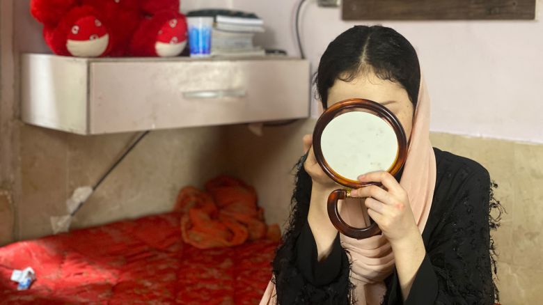 Arzo puts on makeup as she prepares to go outside for an English lesson, one of the very few outings she makes due to fear of arrest. June 3, 2024.