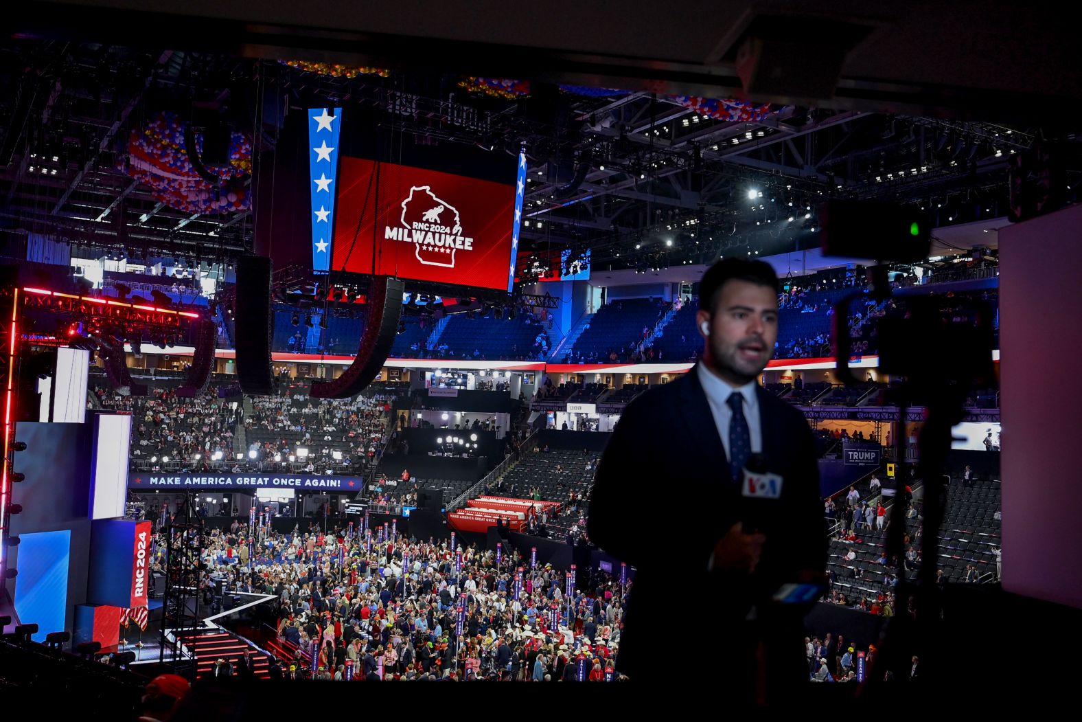 A TV journalist reports from inside the Fiserv Forum on Monday.