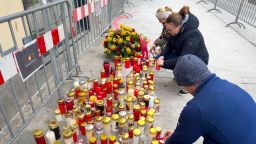 La gente enciende velas en el lugar del apuñalamiento un día después de un ataque que dejó a un adolescente de 14 años muerto y a otros cinco heridos, en Villach, Austria, este domingo.