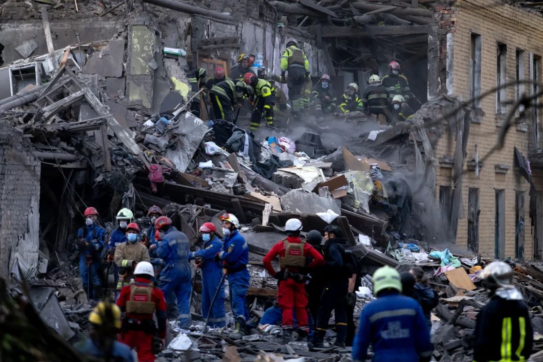 Los equipos de rescate buscan personas bajo los escombros de un edificio de apartamentos destruido por el bombardeo.
