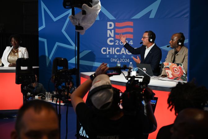 Pennsylvania Gov. Josh Shapiro, second from right, speaks to media inside the United Center on Thursday. Shapiro was on the short list to be Harris' running mate.