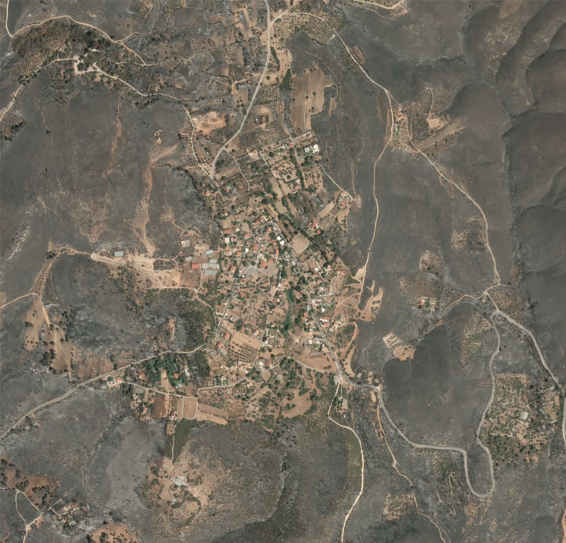 Vothonas, Greece is completely encircled by landscape blanketed in black ash after fires ripped through the region this week.