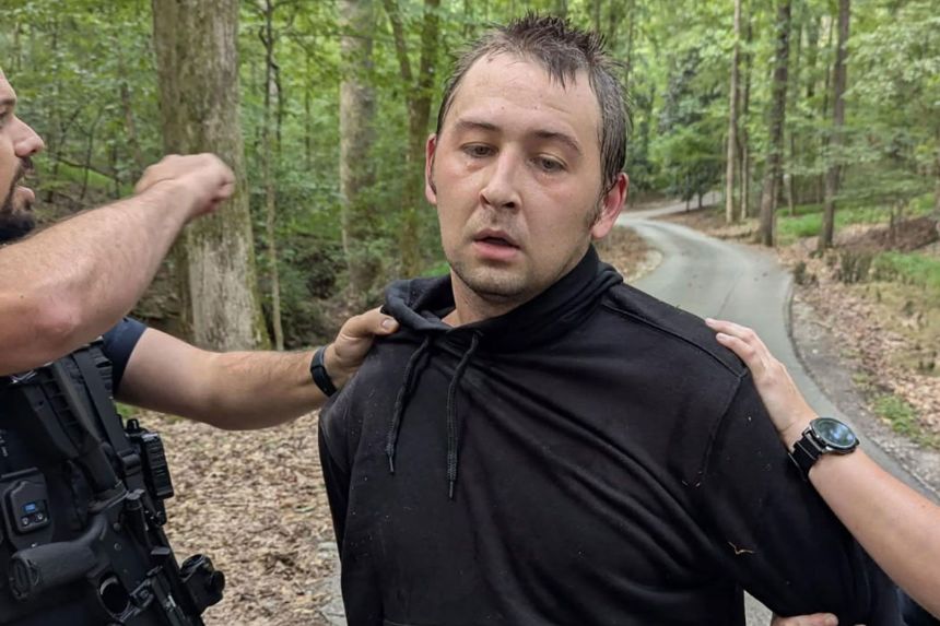Austin Drummond is taken into custody Tuesday in a wooded part of Tennessee.