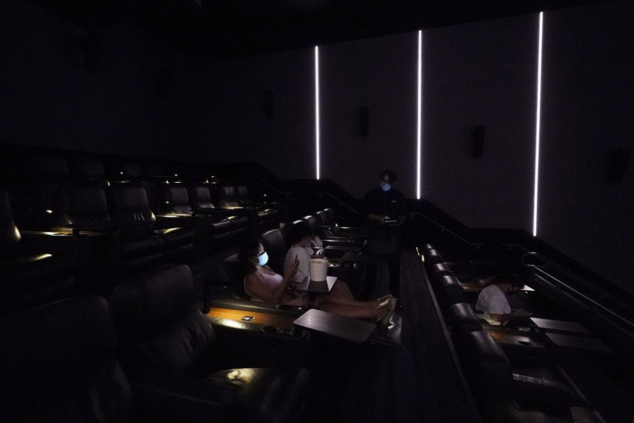 Nancy Killebrew checks her phone as she waits with her daughter Melody for the start of a movie at The Lot on Thursday, Sept. 3, in San Diego.