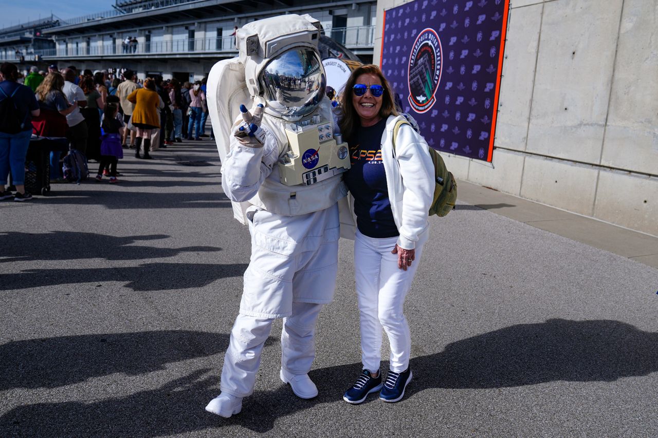 Tamra Sylvester poses with a person dressed as an astronaut during a eclipse viewing event at the Indianapolis Motor Speedway.