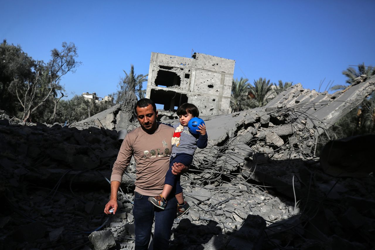 Palestinians walk through the rubble of a destroyed building following an Israeli strike in Deir Al Balah, Gaza on November 23.