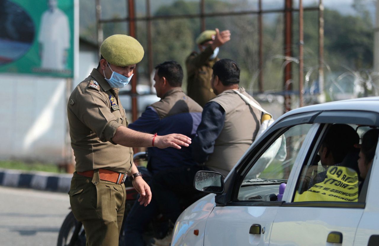 Jammu and Kashmir policemen stop drivers to encourage them to utilize a coronavirus screening facility in Lakhanpur, India on March 4.