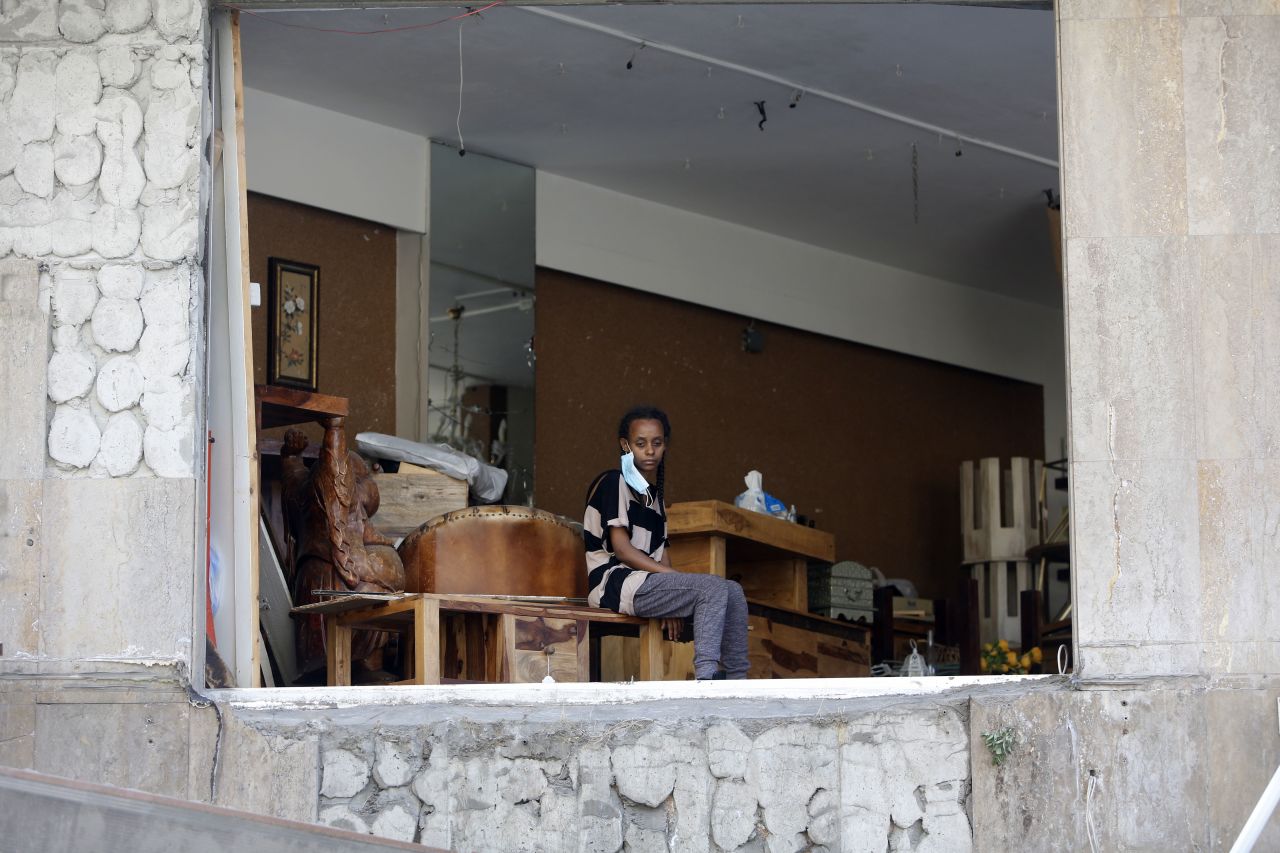 A person looks out of the collapsed facade of an apartment on August 5.