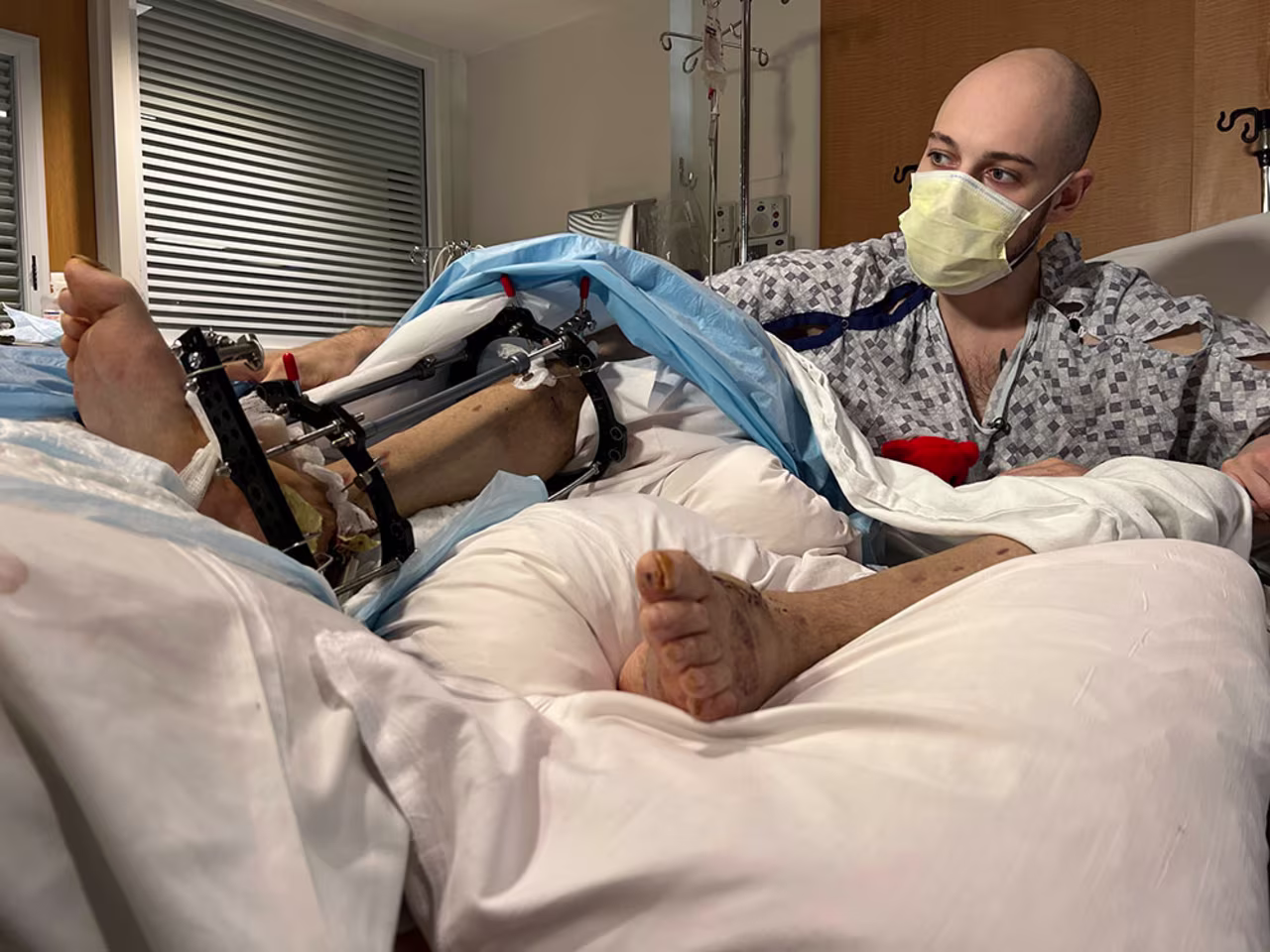 Vladyslav Orlov sits in his hospital bed after two major reconstructive surgeries.