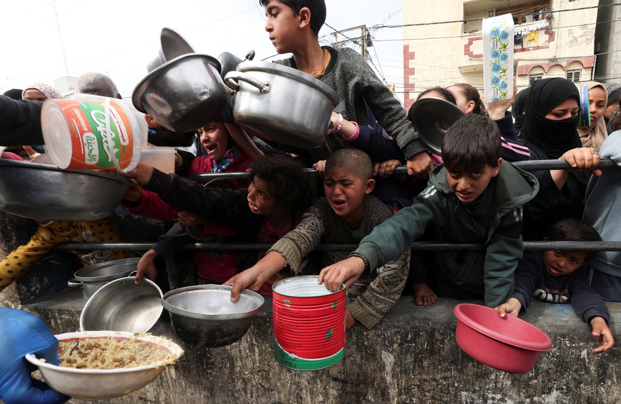 Palestinian children wait to receive food cooked by a charity kitchen in Rafah, Gaza, on February 13.