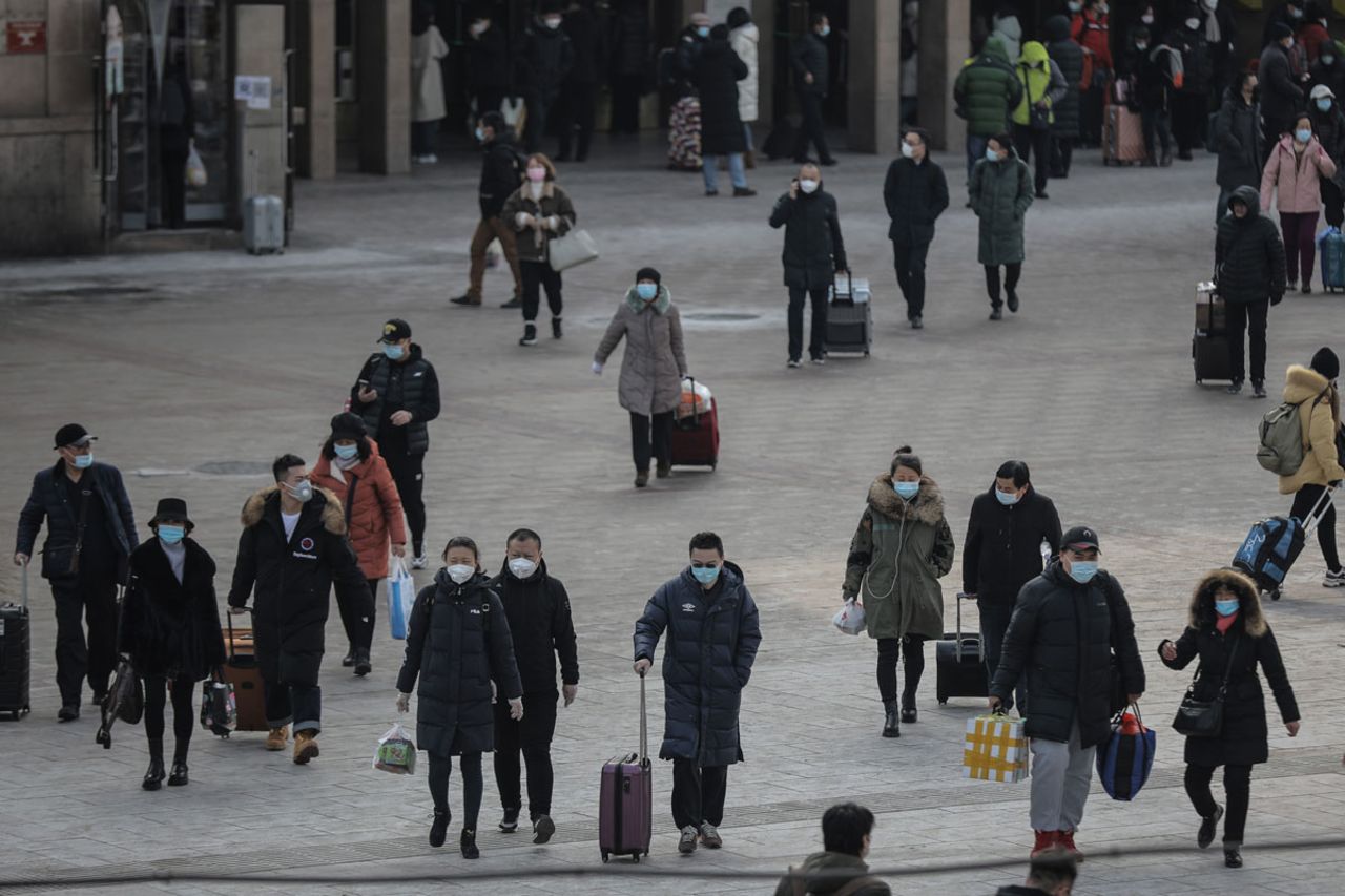 People wearing protective face masks are seen at the Beijing Railway Station on January 19, ahead of the Chinese New Year travel rush.