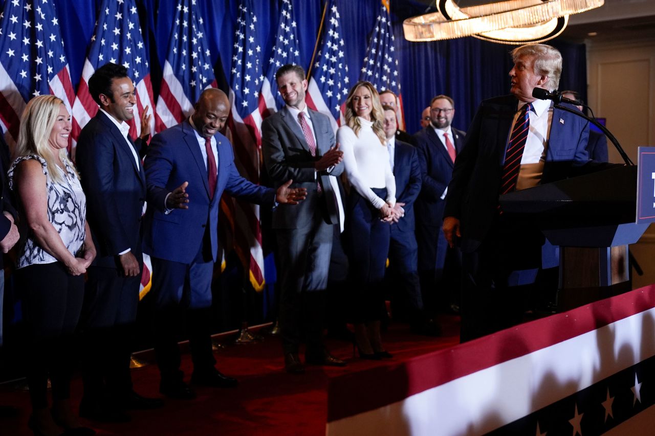 Former President Donald Trump turns to look at Sen. Tim Scott as he speaks at a primary election night party in Nashua on Tuesday.