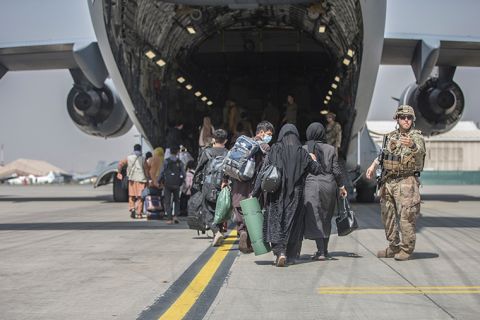 In this image provided by the U.S. Marine Corps, families begin to board a U.S. Air Force Boeing C-17 Globemaster III during an evacuation at Hamid Karzai International Airport in Kabul, Afghanistan, Monday, August 23.