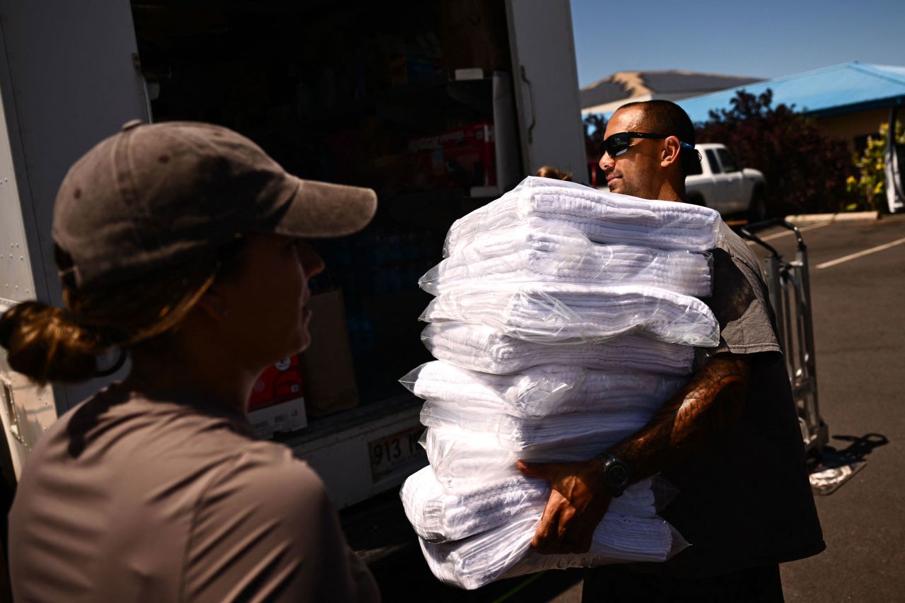 Volunteers carry donated supplies to distribute to fire victims in Wailuku, Hawaii, on Saturday.?