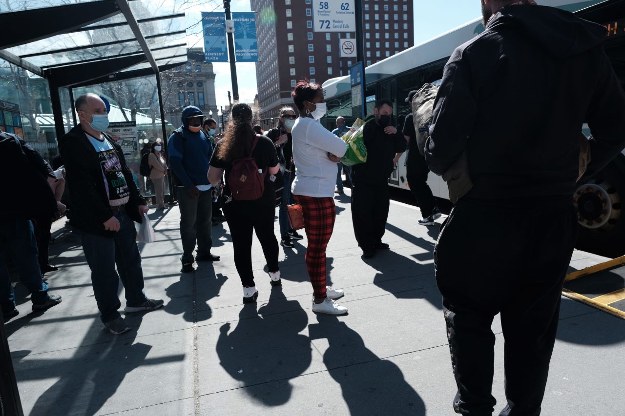 People wait at a bus stop on April 8 in Providence, Rhode Island. 