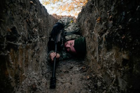 A Ukrainian soldier hides from a helicopter airstrike near Demydiv, Ukraine on March 10. 