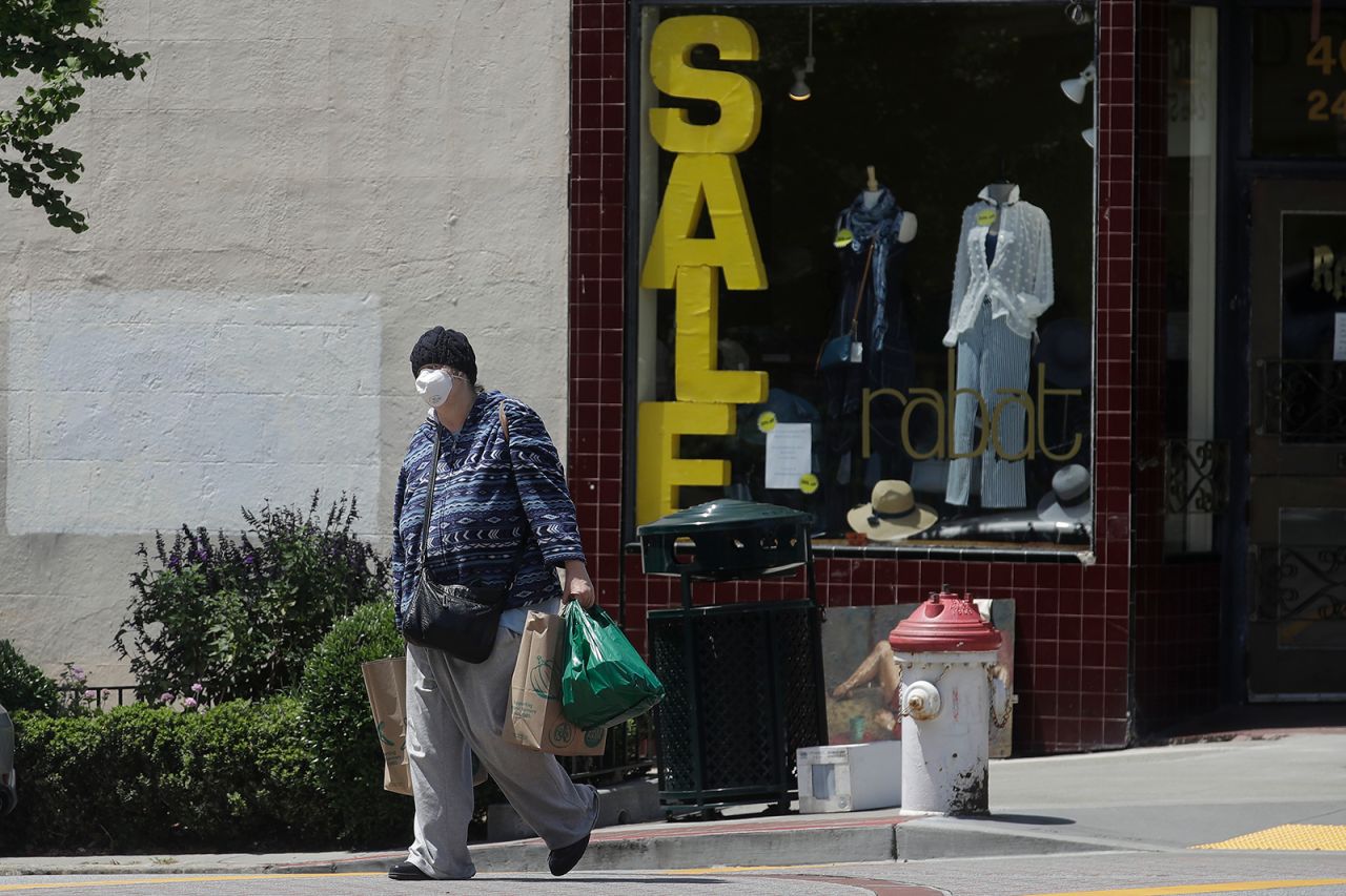 A woman carries shopping bags during the coronavirus outbreak in San Francisco, on Thursday, May 7.