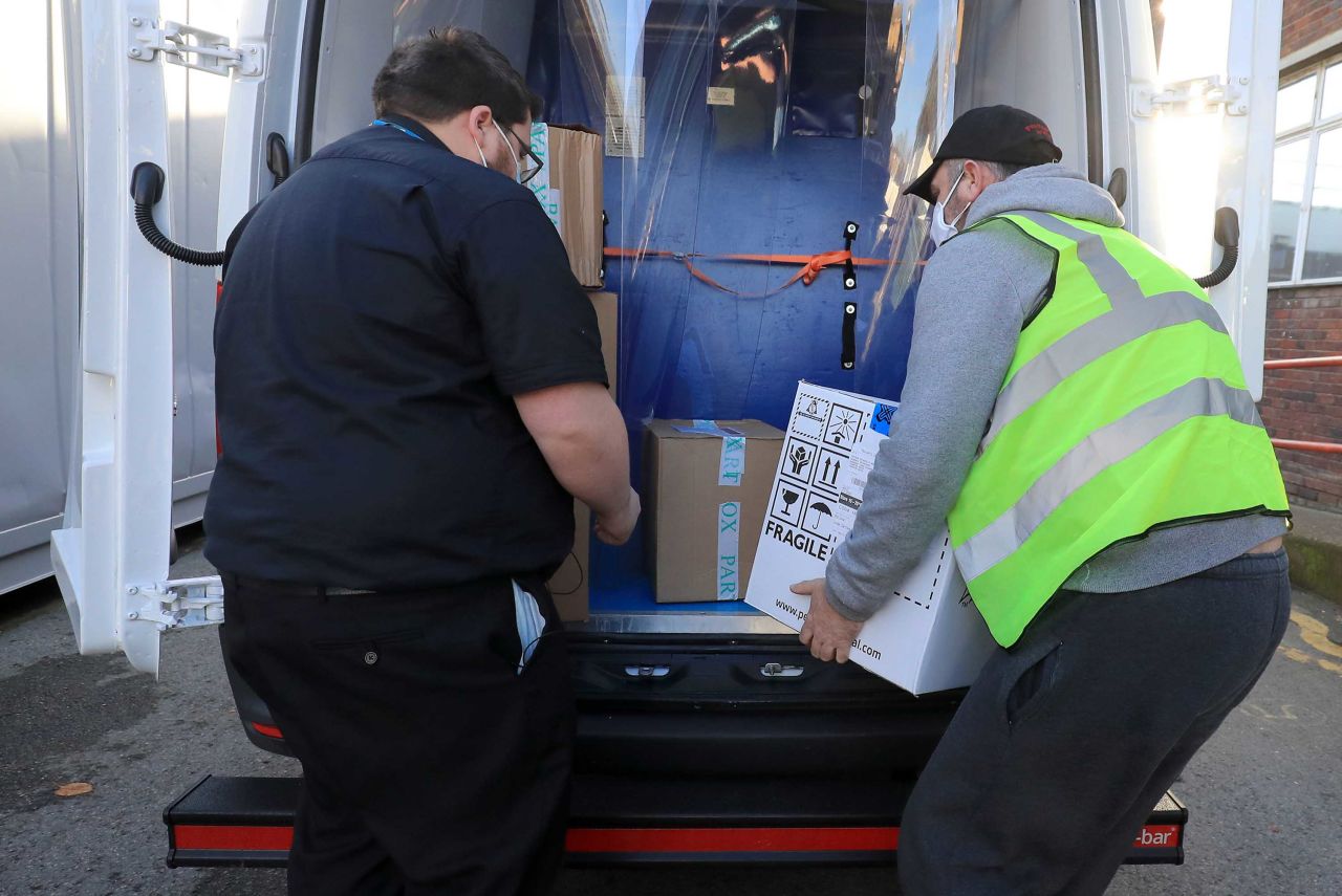 A pharmacy technician from Croydon Health Services, left, takes possession of the first batch of Covid-19 vaccinations at Croydon University Hospital in south London on December 5.