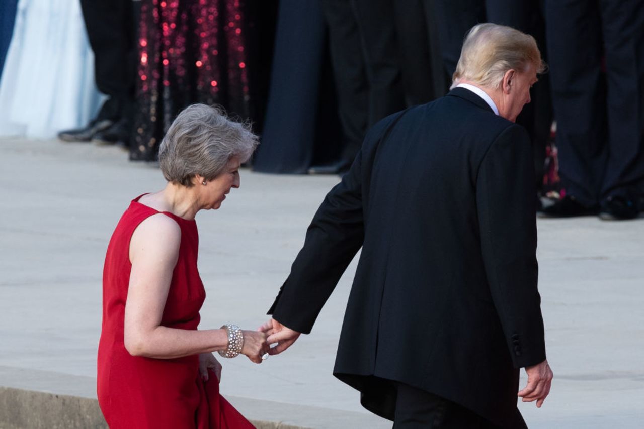 British Prime Minister Theresa May (L) walks with US President Donald Trump (R) as Trump arrives for a black-tie dinner with business leaders at Blenheim Palace.