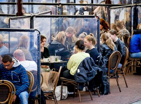 People sit at terraces with plastic screens in Groningen, The Netherlands, on September 25, 2020. 
