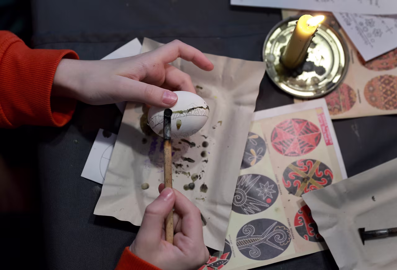 A child decorates an Easter egg in Lviv, Ukraine, on Sunday. The Easter egg decorating project was put on by the Plast National Scout Organization of Ukraine for children who had fled from their hometowns. 