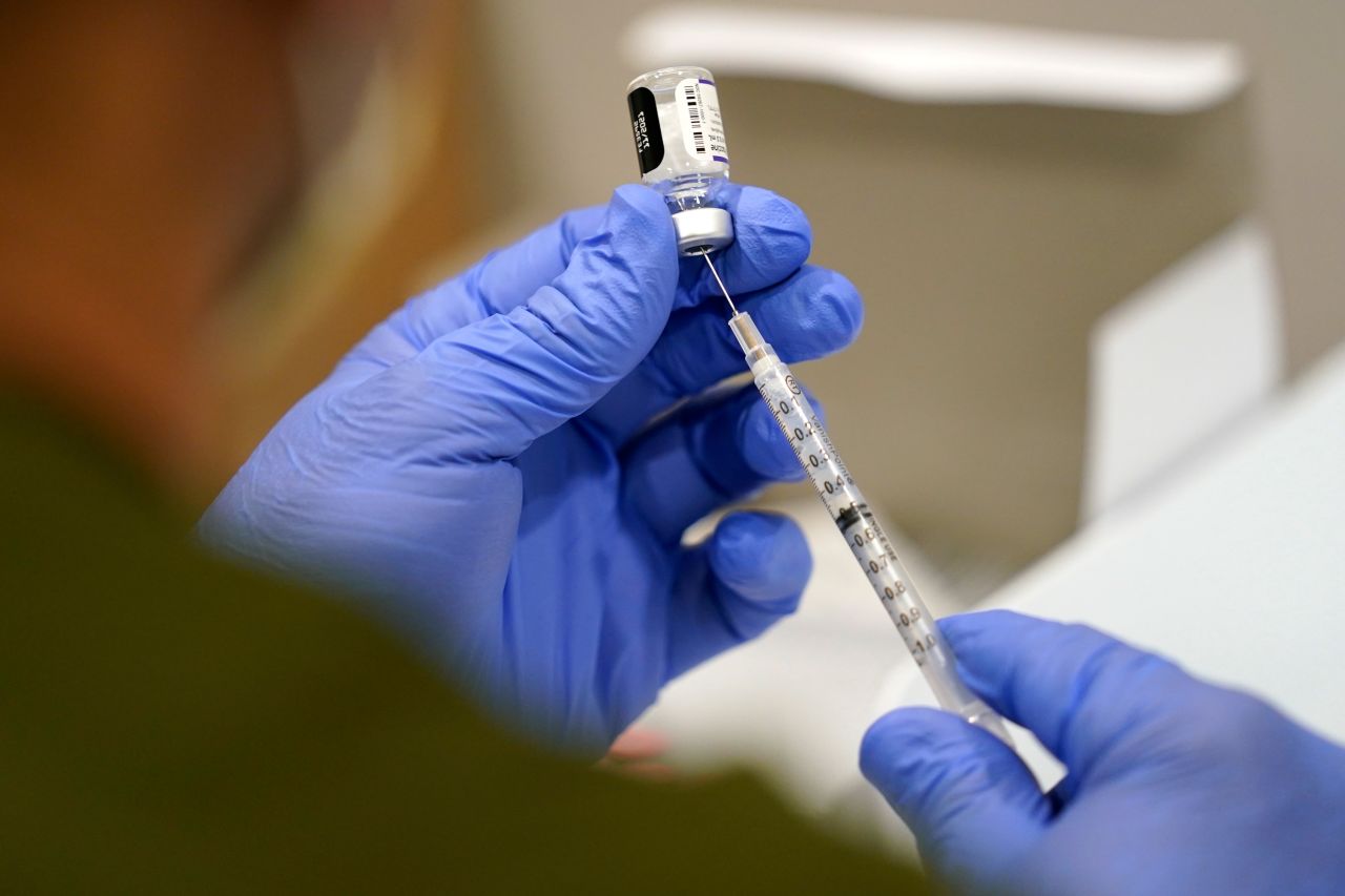 A healthcare worker fills a syringe with the Pfizer COVID-19 vaccine at Jackson Memorial Hospital on October 5, in Miami.??