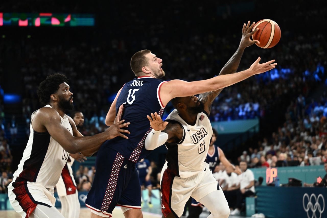 Serbia's Nikola Jokic and USA's LeBron James fight for the ball.