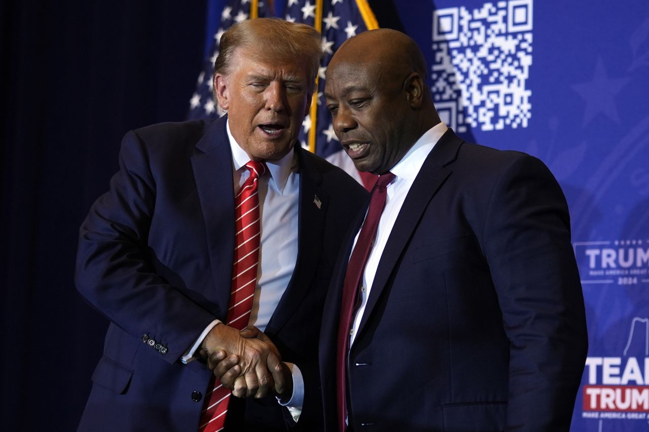 Republican presidential candidate and former President Donald Trump shakes hands with Sen. Tim Scott at a campaign event in Concord, New Hampshire on January 19.