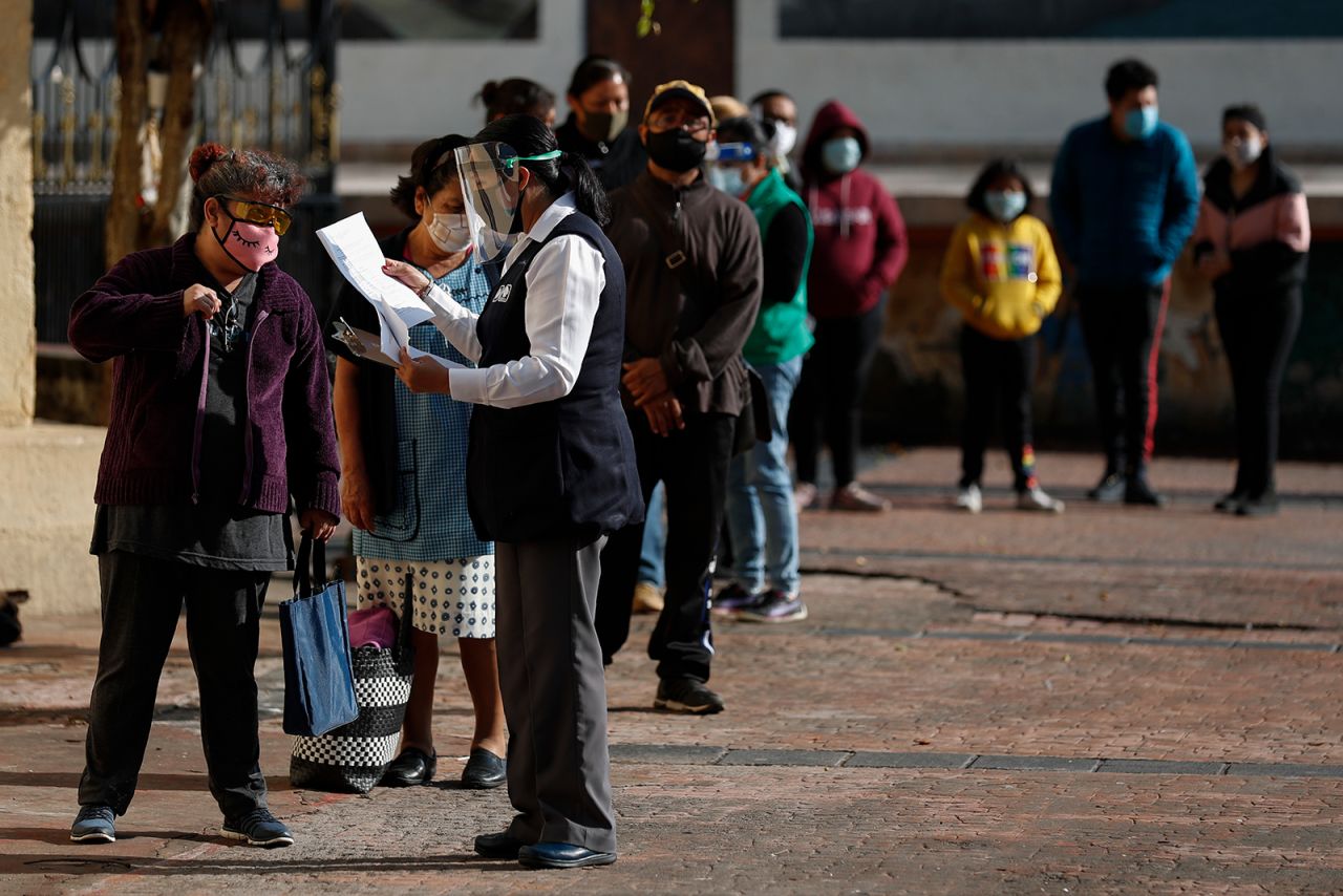 A health department worker collects patient data from people waiting in line for Covid-19 testing, at a mobile diagnostic tent in Mexico City on July 24.