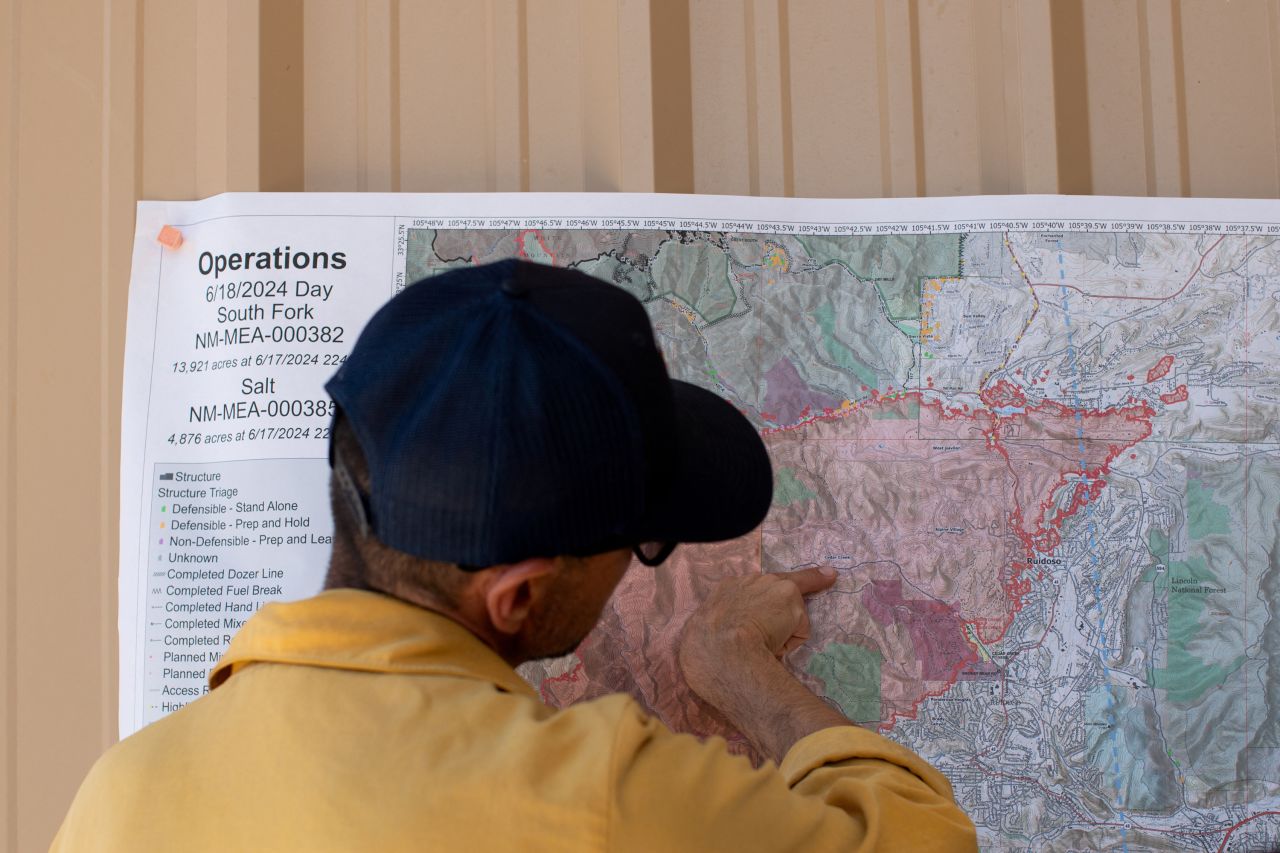 USDA Fire Manager Errick Kimbrell shows firefighters where the South Fork Fire spread overnight and its suspected direction of travel in Ruidoso, New Mexico, on June 18.