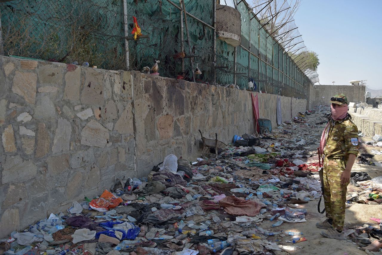 A Taliban fighter stands guard near where a bomb went off at Kabul airport on August 27.