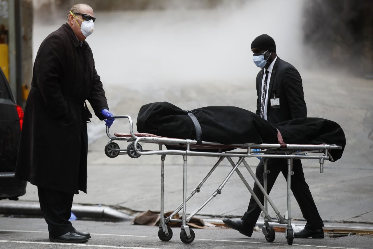 A funeral director wheels a body outside The Brooklyn Hospital Center in Brooklyn, New York, on April 9.