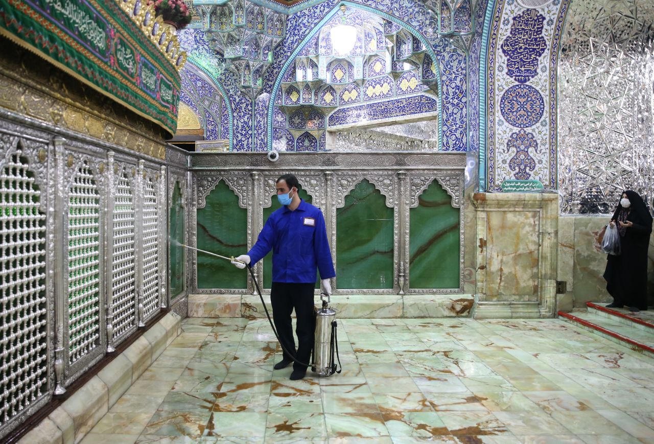 A worker disinfects Qom's Masumeh shrine on Tuesday. The city is the epicenter of Iran's virus outbreak. 