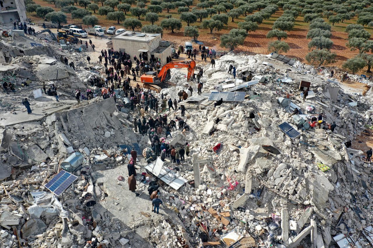 Residents, aided by heavy equipment, search for victims and survivors amidst the rubble of collapsed buildings in the village of Besnia in Syria's Idlib province, on February 6.