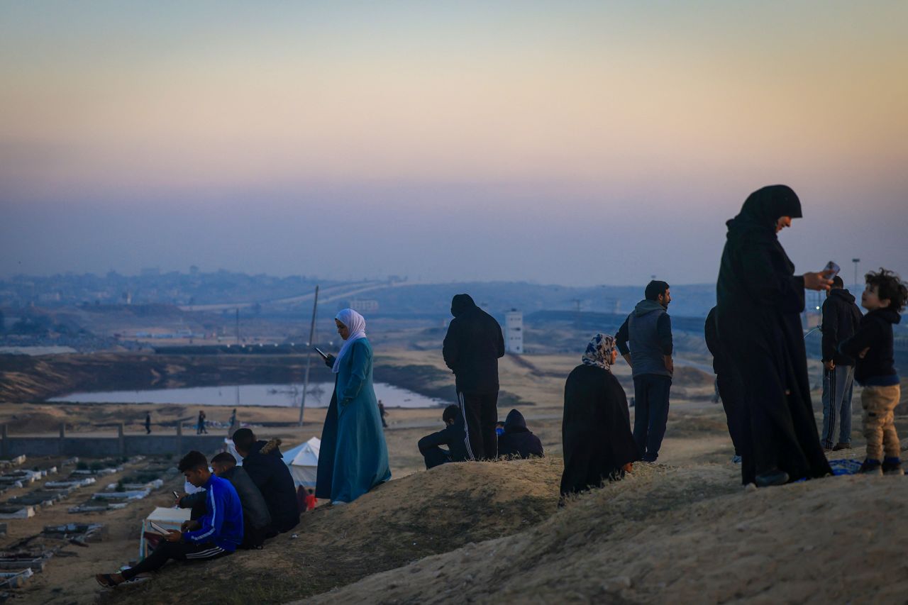 Displaced Palestinians using eSIM cards attempt to get a signal on January 19 on a hill in Rafah, on the southern Gaza border with Egypt.