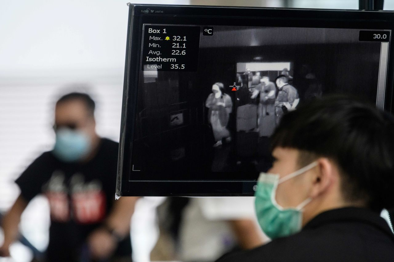 A worker at the Hong Kong International Airport monitors a thermal screening display as passengers arrive on March 10.